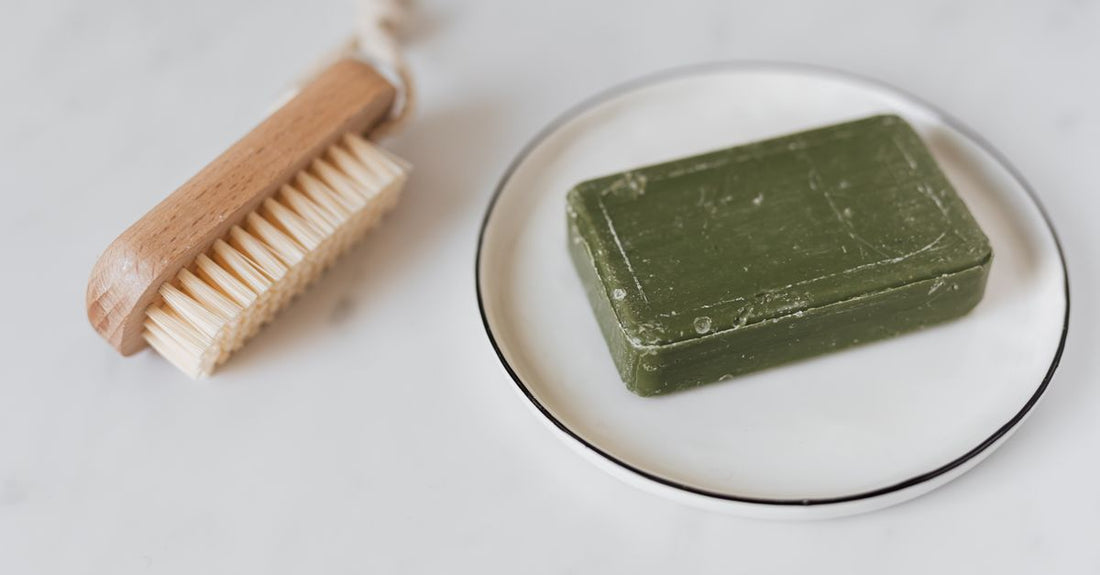 Natural bristle best bath & body brushes 2026 arranged on a light marble surface with a folded white towel, evoking a spa-like bathroom setting.