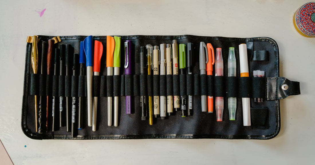 A selection of eyeliner pens, pencils and gel pots on a white background, illustrating how to choose eyeliner for different looks.