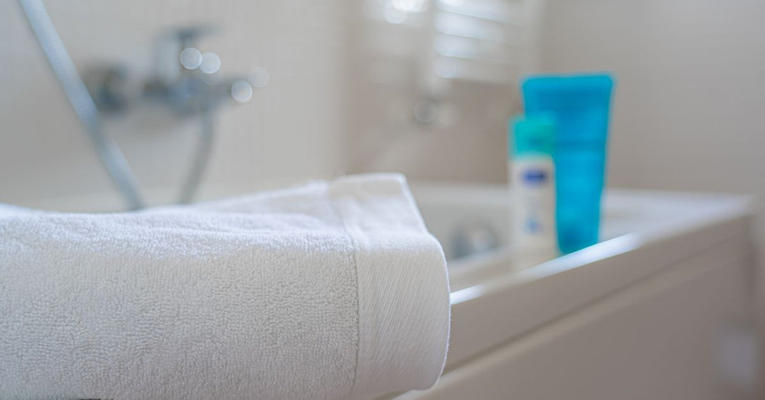 Best bath & bathing accessories 2026 arranged on a bathroom shelf: bath salts, a loofah, and a wooden brush.