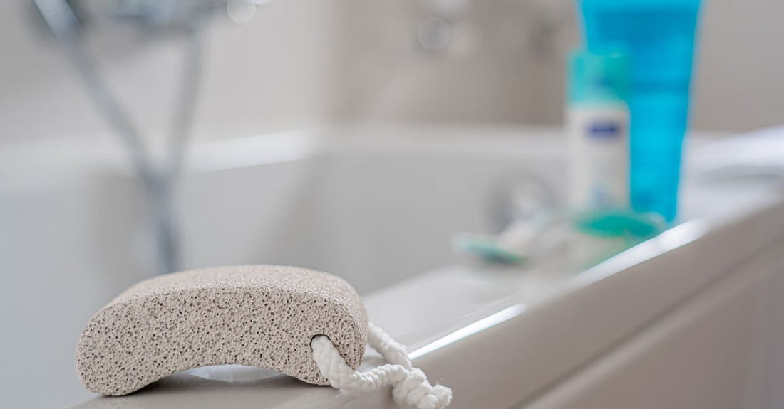 A natural pumice stone used for how to remove calluses from feet, sitting on a clean bathroom surface.