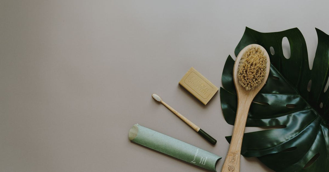 Collection of best bath & body brushes 2026 arranged on a white marble surface, including a long-handle brush, a silicone scrubber, and a natural bristle dry brush.