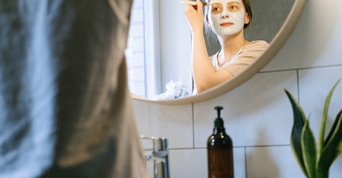 A selection of hair mask jars and tubes on a bathroom shelf, illustrating different types of conditioning treatments for learning how to use hair mask properly.