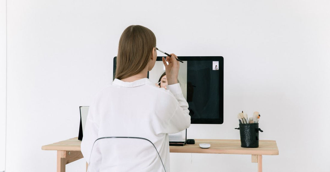 A sleek desk makeup mirror with LED lights and magnification, among beauty products on a vanity.