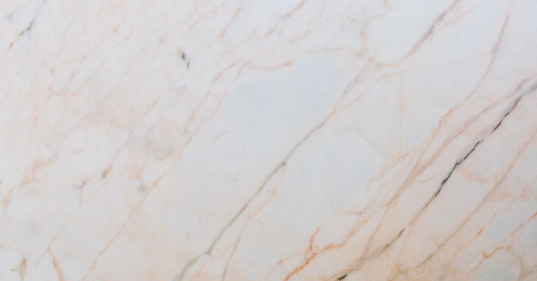 A sleek facial steamer device emitting a fine mist on a marble bathroom counter, illustrating how to choose facial steamers for at-home spa results.