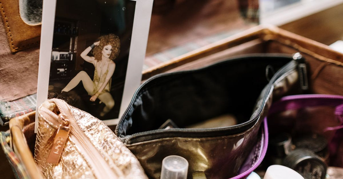 A collection of cosmetic bags in varying sizes and materials laid out on a light surface, illustrating how to choose cosmetic bags by function and style.