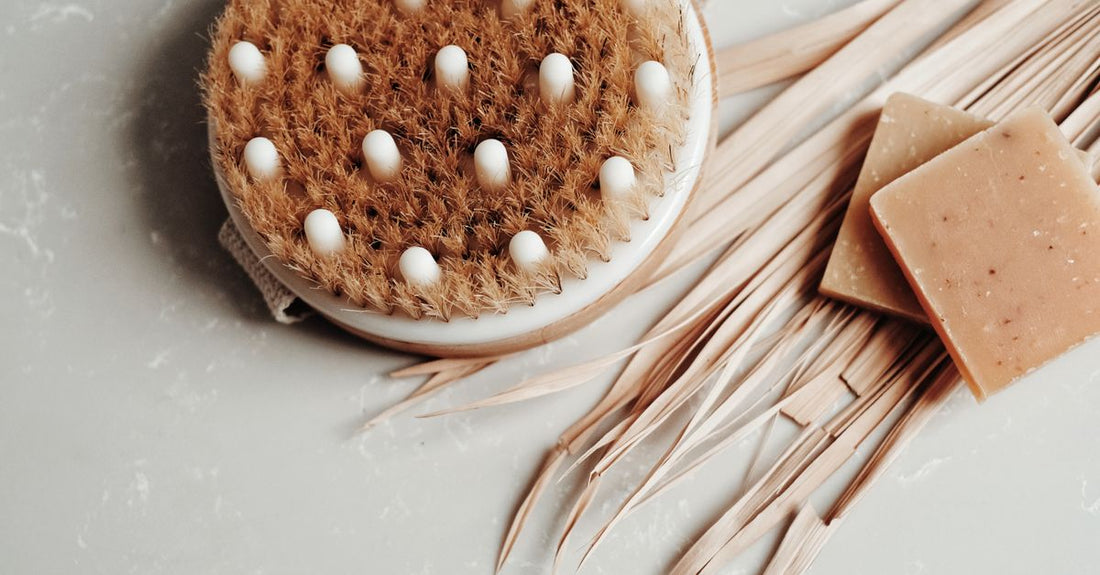 A selection of the best bath and body brushes 2026 arranged on a marble surface, including natural bristle and silicone options.