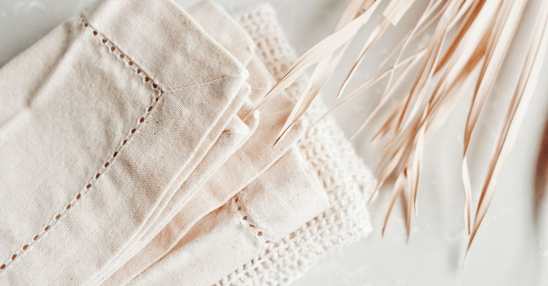 A selection of soft cotton cleansing cloths and towelettes arranged on a white surface, illustrating how to choose cloths & towelettes for different skin types.