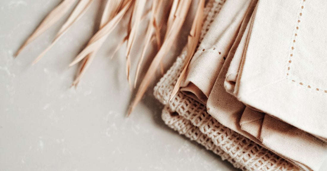 Stacked clean cotton cloths and towelettes on a bathroom shelf, part of a cloths & towelettes buying guide