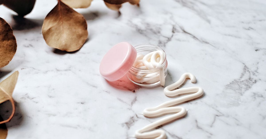 Eye cream jar on a white marble surface, representing the best eye cream for dark circles UK available at Avelisse
