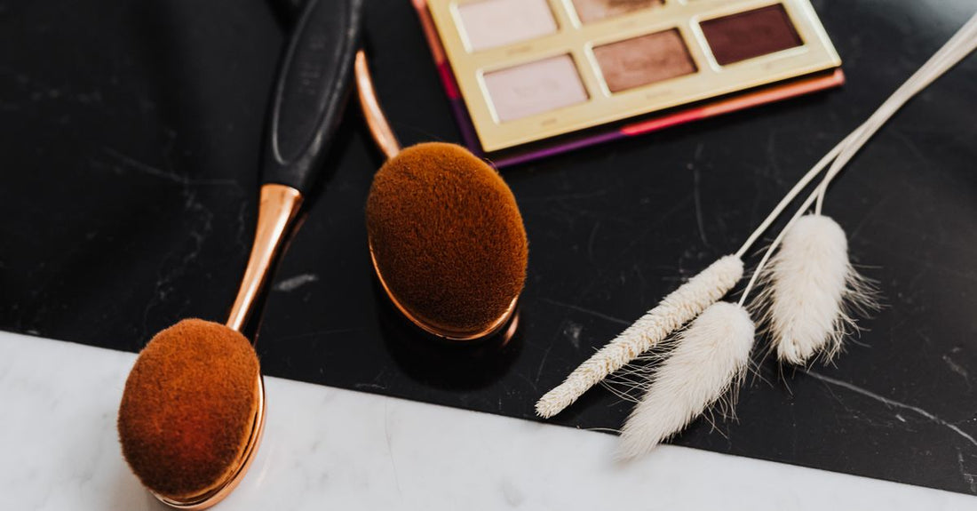 A flatlay of assorted bronzer compacts and palettes in warm terracotta and golden hues, demonstrating the variety in a bronzers buying guide.
