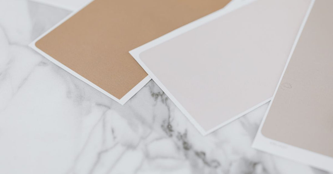 A selection of concealer shades displayed on a marble surface, illustrating how to choose the right concealer shade for your skin tone.