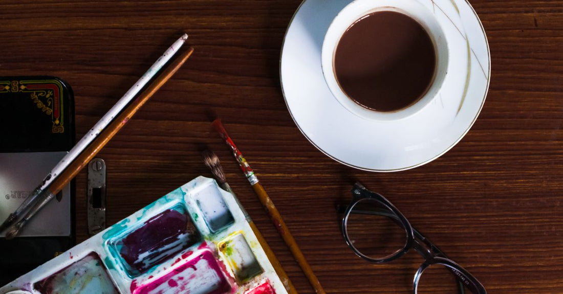A flatlay of colourful body paint palettes and brushes on a white surface, illustrating how to choose body paint for UK shoppers.
