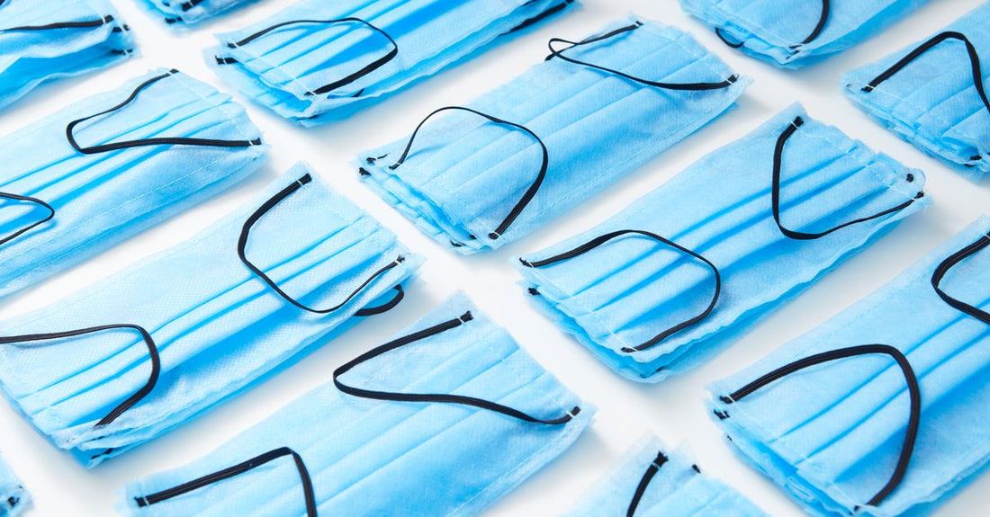 Masks buying guide flatlay: sheet masks, clay pot, and sleeping mask arranged on marble.