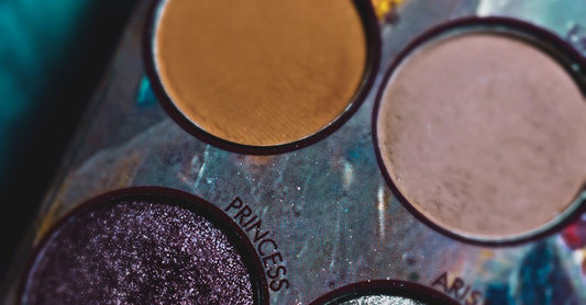 A selection of makeup palettes arranged on a white background showing various eyeshadow and face colour options in a flat lay photograph.