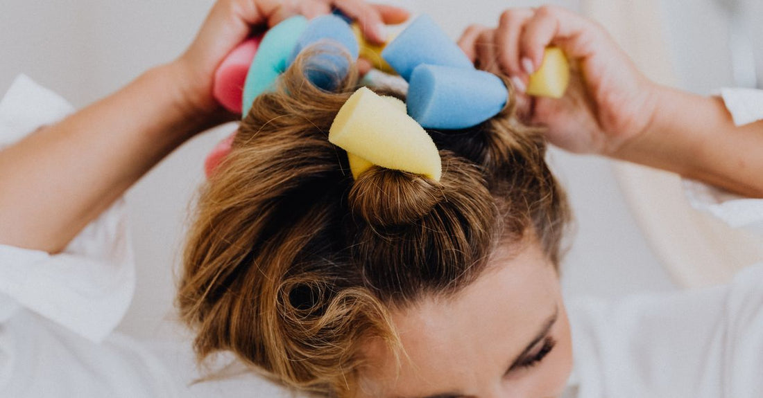 A flatlay of colourful hair rollers on a white background, illustrating a hair rollers buying guide for beginners.