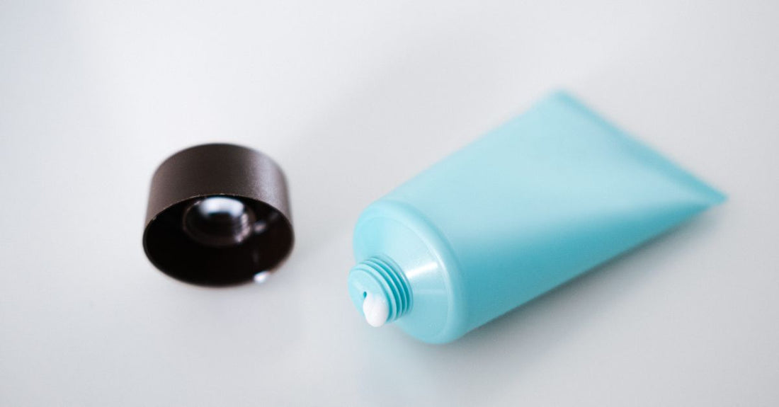 A sleek tube of eyeshadow primer on a clean white surface, illustrating how to choose eyeshadow bases & primers UK for crease-free, vibrant eye makeup.