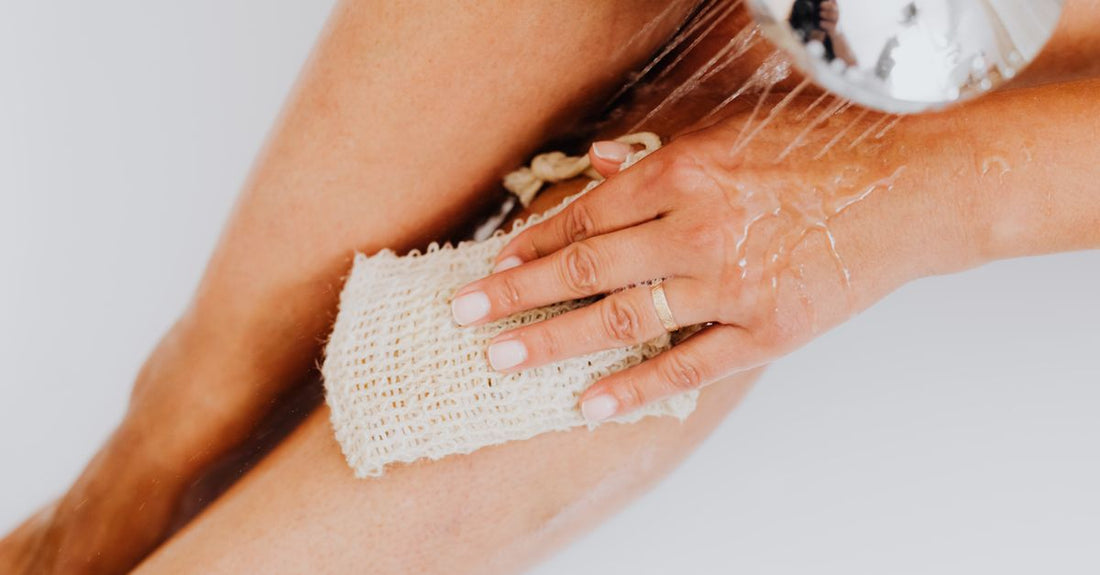 Exfoliating mitts and self-tanning removal products on a clean surface, showing how to remove self tanner from hands