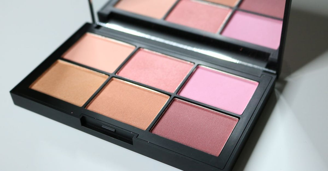 A selection of bronzer compacts and palettes laid out on a marble surface, illustrating a bronzers buying guide.