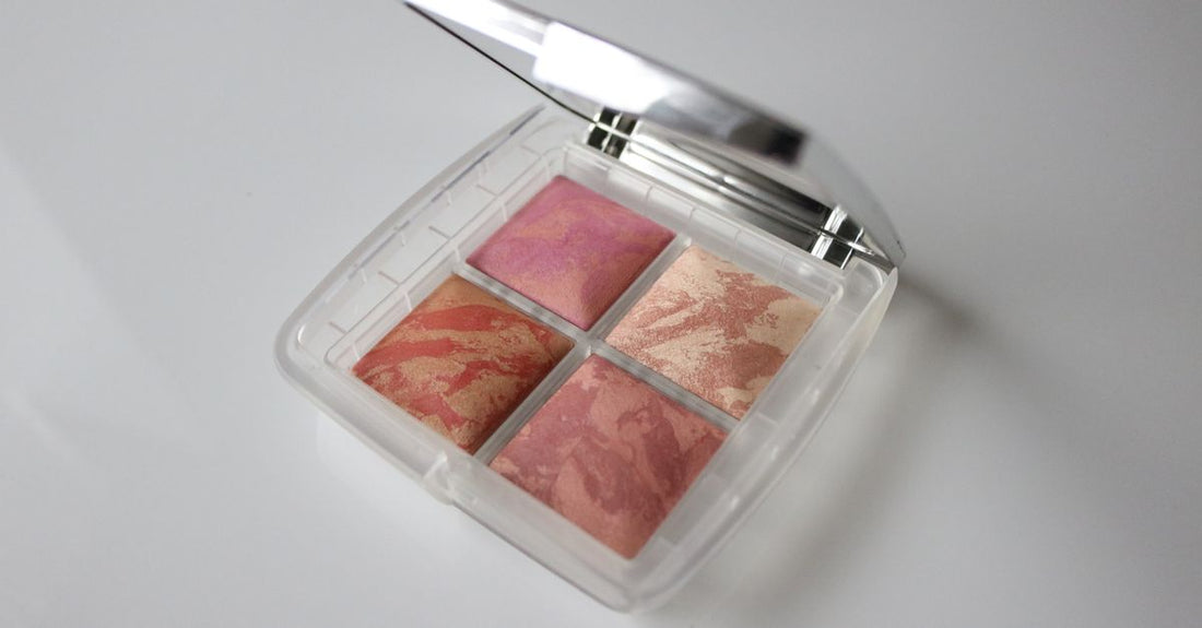 A selection of the best blush compacts for 2026, displayed on a marble surface with beauty accessories.