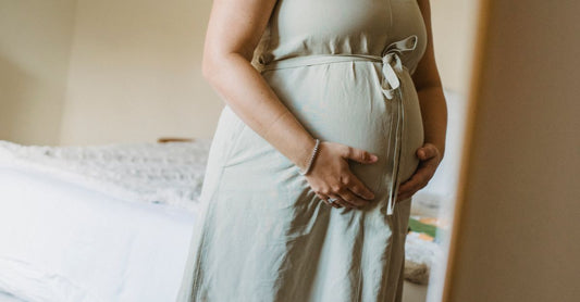 A flatlay of pregnancy-safe skincare products including stretch mark creams and belly oils on a white background, representing where to buy maternity online.
