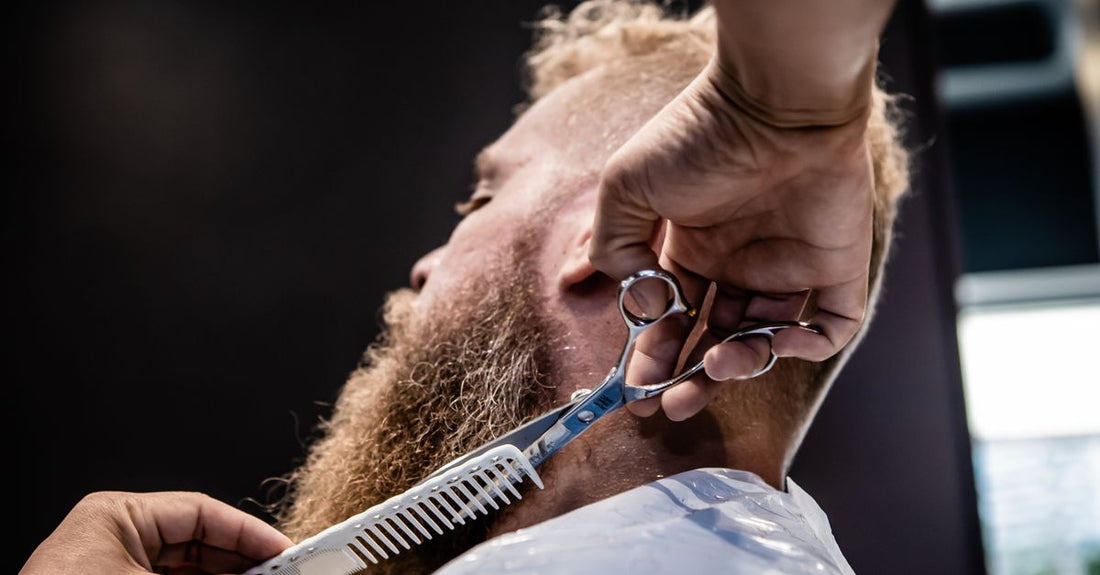 Close-up of a high-end beard and mustache trimmer with stainless steel blades on a dark grooming station background, representing the best beard & mustache trimmers 2026.