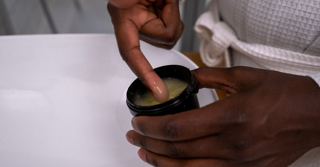 A jar of gentle cleansing balm, the best makeup remover for sensitive skin, surrounded by soft cotton pads on a light surface.