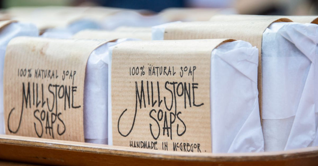 A collection of artisan soap bars on a wooden shelf, illustrating a soaps buying guide UK for beginners.
