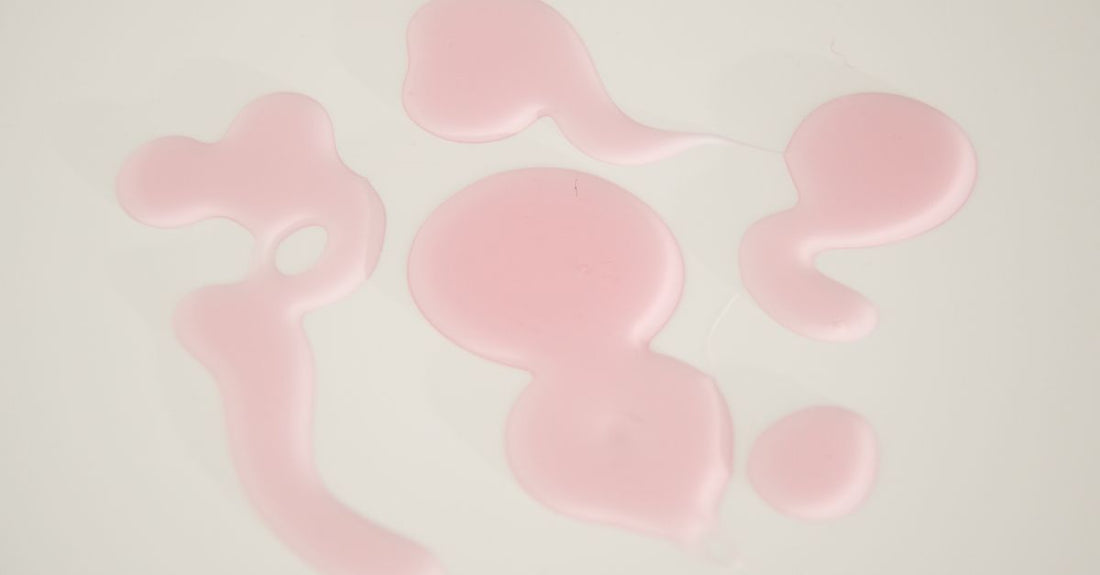Three body wash bottles on a marble surface, representing budget, mid-range and luxury options in a body wash buying guide.