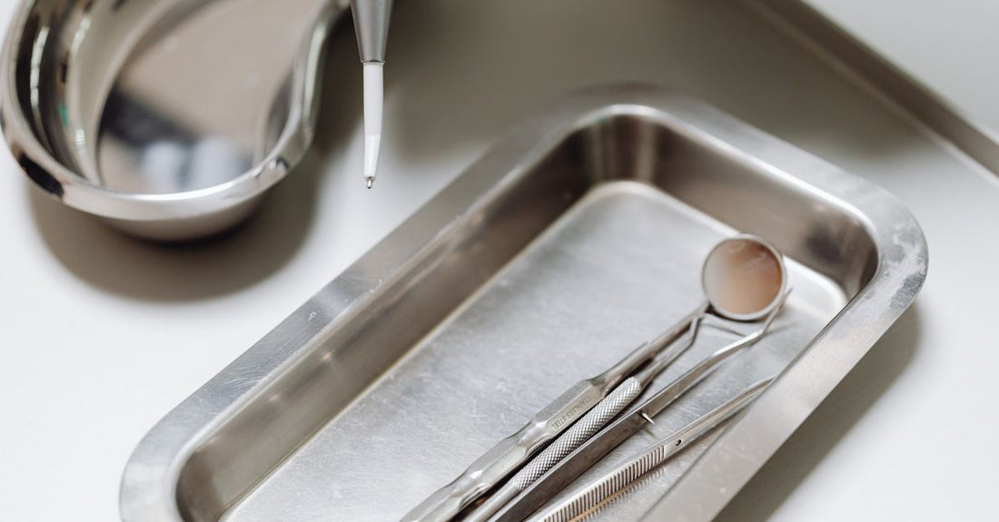 Stainless steel blackhead and blemish remover tools arranged on a clean surface, showing different tip shapes for pore extraction.
