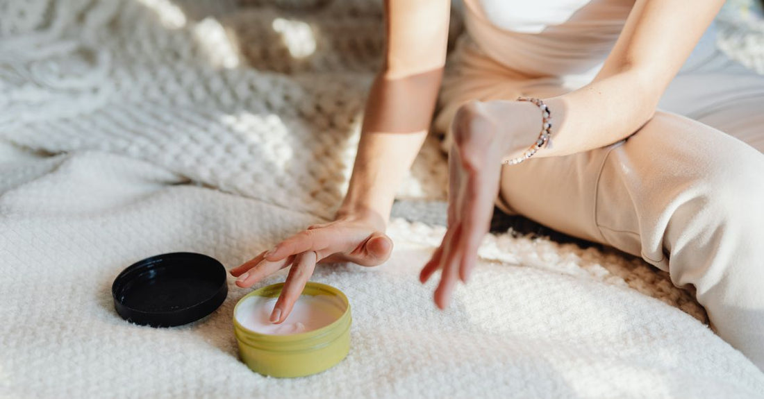 A jar of whipped body butter on a bathroom shelf, illustrating how to choose body butters for dry skin.