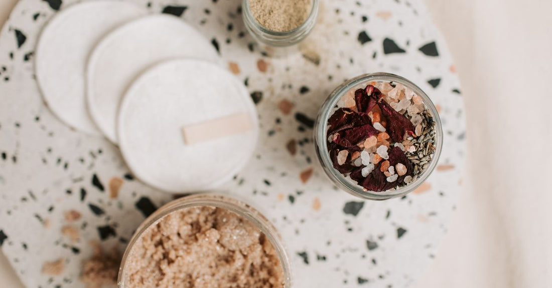 Facial kits buying guide UK – a flatlay of miniature skincare bottles and jars arranged on a light background, representing a complete routine.