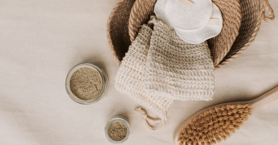 A flatlay arrangement of soft reusable facial cloths and disposable towelettes on a marble surface, illustrating the cloths & towelettes buying guide.