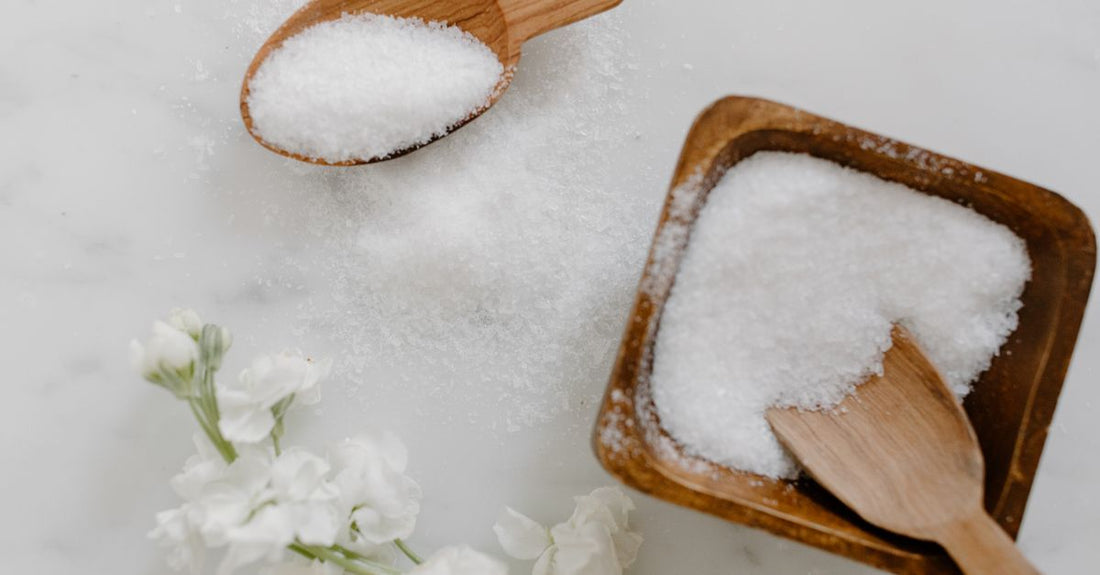 An array of different bath salts in glass jars on a wooden surface, illustrating a bath salts buying guide
