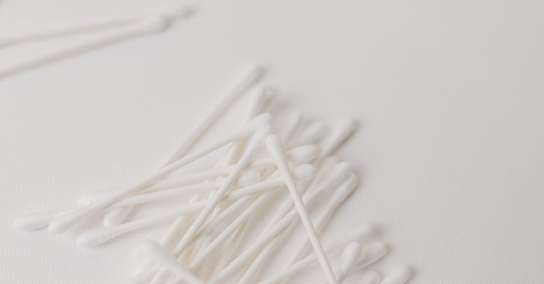 Close-up flatlay of various cotton swabs on a neutral surface, showcasing different tip shapes and materials for a cotton swabs buying guide.