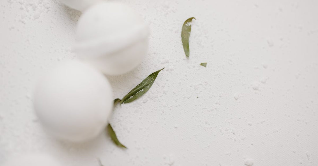 An assortment of colourful handmade bath bombs arranged on a marble surface, illustrating how to choose bath bombs based on ingredients and scent.