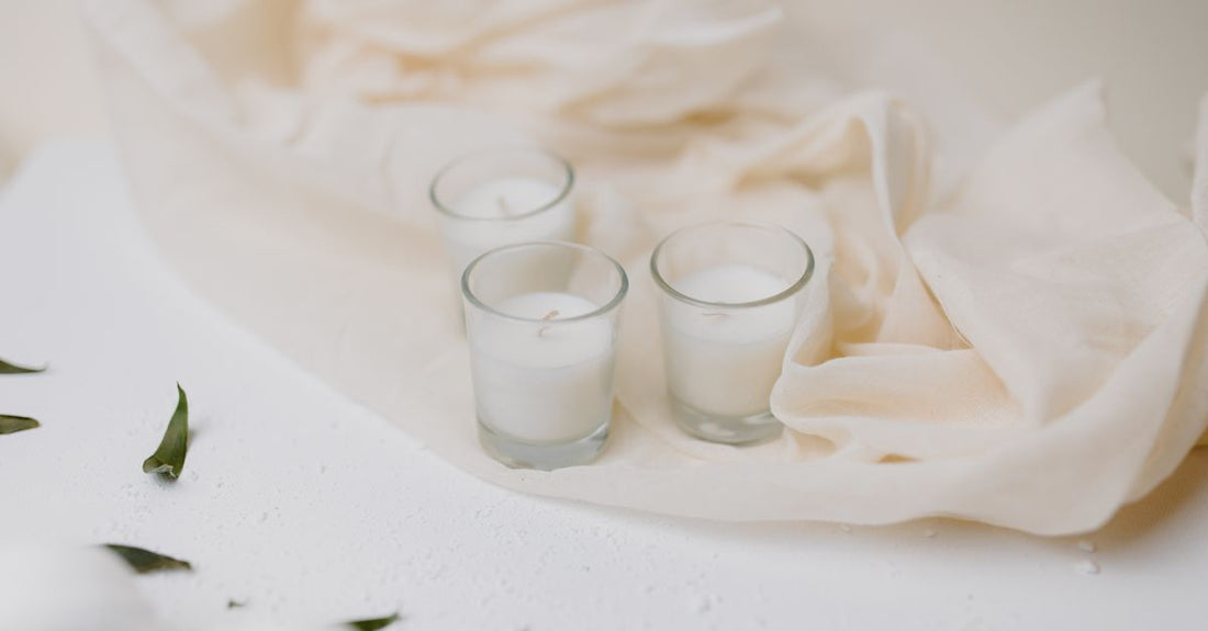 A set of soft, white cotton cleansing cloths neatly stacked on a marble surface, illustrating a cloths & towelettes buying guide.