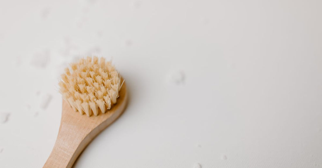 A natural boar bristle beard brush resting on a dark, textured surface, illustrating how to grow a beard faster naturally with proper grooming.