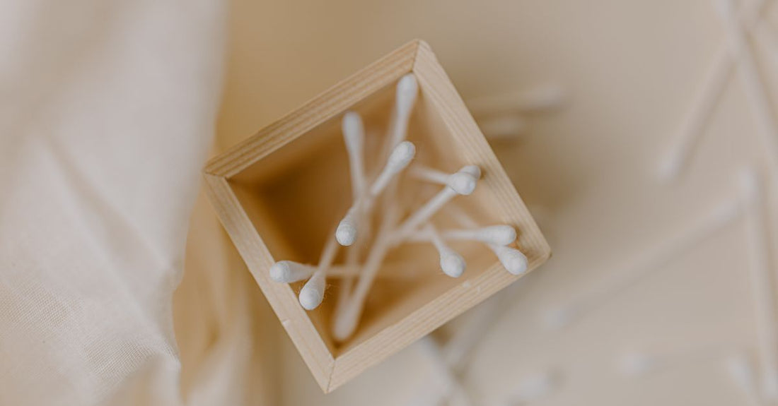 A neatly arranged box of best cotton swabs 2026 with tightly-wound tips on a clean white surface, showing wooden sticks and pure white cotton heads.