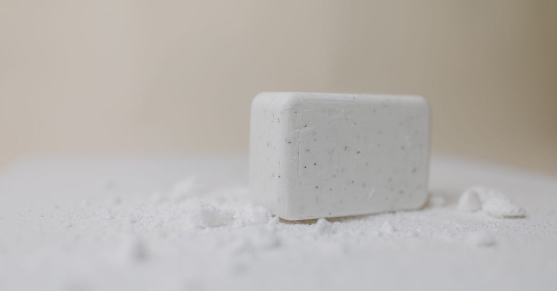 An assortment of cleansing bars on a neutral-toned surface, helping you learn how to choose bars for a complete skincare routine.