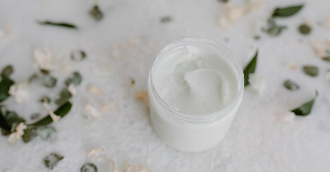 Best CC cream for redness UK displayed in a green jar on a light surface with skincare ingredients.