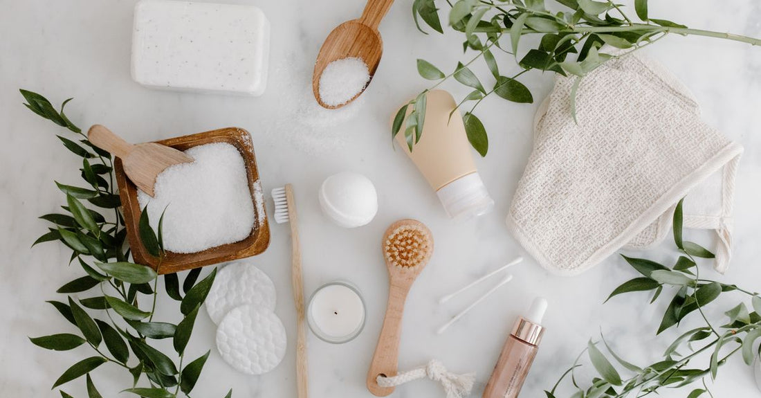 A flatlay photo of self tanner products for face, including a bottle of tanning drops and a mitt, demonstrating how to use self tanner for face properly.