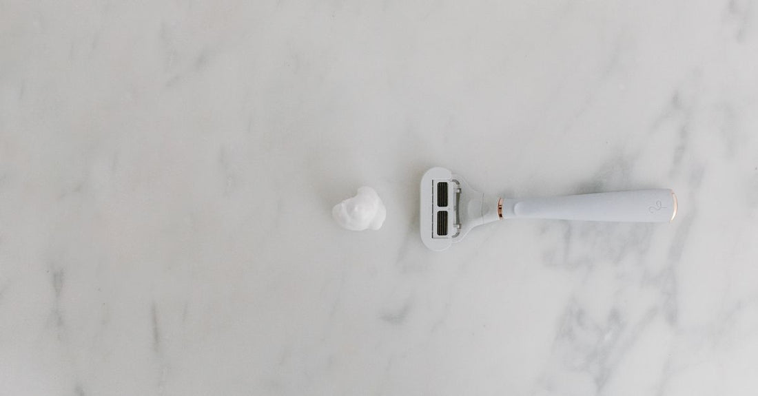 Sleek purple bikini trimmer resting on a cool marble surface, exemplifying the best bikini trimmers 2026 for precise grooming.
