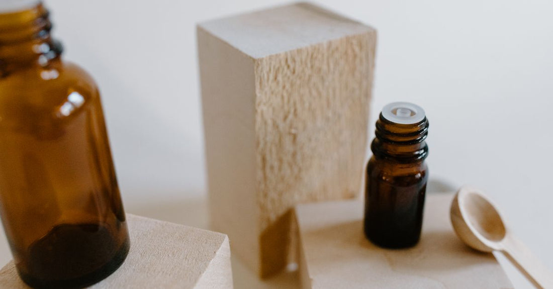 Selection of amber glass dropper bottles and pipettes on a clean white surface, illustrating how to choose droppers for skincare.