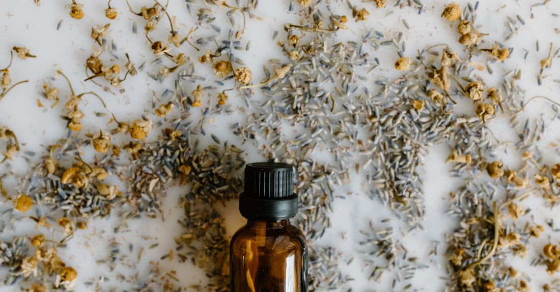 A flatlay of various hair oil bottles on a white marble surface, illustrating how to tame frizzy hair with oil.