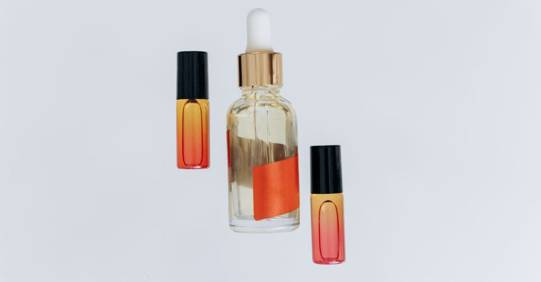 Glass bottle of hair growth oil with dropper on neutral surface