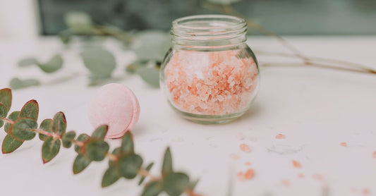 Assorted bath salts in glass jars on a bathroom shelf, showcasing the best bath salts for relaxation UK.