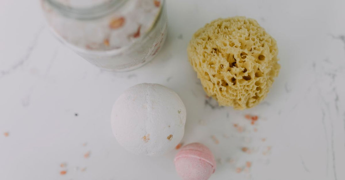 A jar of body scrub on a marble surface, illustrating how to use a body scrub correctly for smooth skin.