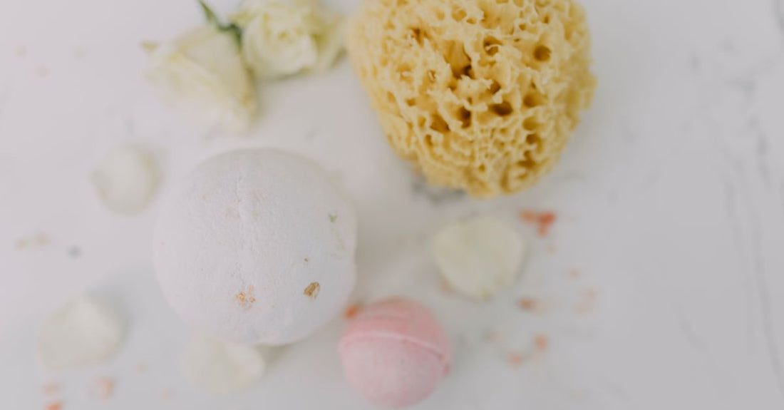 A collection of different shapes and colours of makeup blenders and sponges on a white surface.