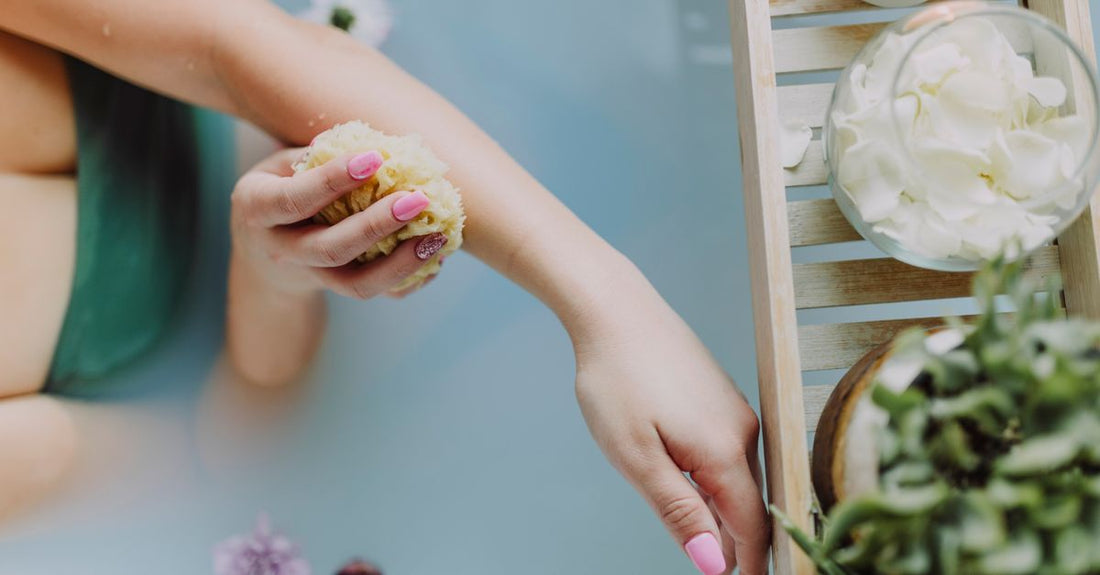 A flatlay of exfoliating bath sponges and a bamboo back brush – how to choose bath & bathing accessories UK