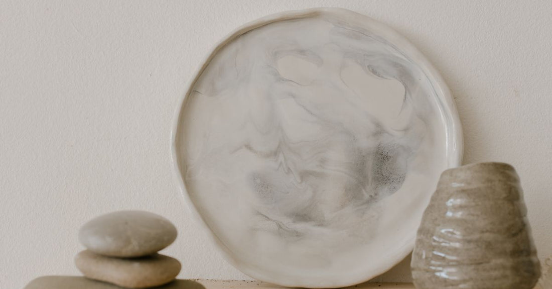 A selection of face masks including a clay mask in a glass jar on a marble surface, illustrating how to choose masks for different skin types.